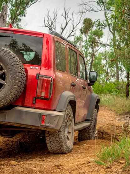 GWM Tank 300 flexing on uneven terrain with Dobinsons suspension upgrade, demonstrating off-road performance.